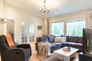 a living room with a blue couch and a table at Northern Lights Kota Stay By BookLapland in Rovaniemi