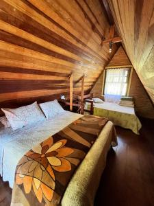 1 Schlafzimmer mit 2 Betten in einer Holzhütte in der Unterkunft Chalé Represa Varanda do Sol - Chalé Alvenaria in Joanópolis