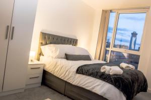 a bedroom with a large bed with a window at CENTRAL Luxury 2BR Apartment Manchester in Manchester