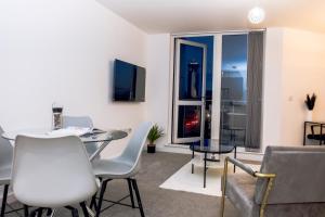 a living room with a table and chairs and a window at CENTRAL Luxury 2BR Apartment Manchester in Manchester