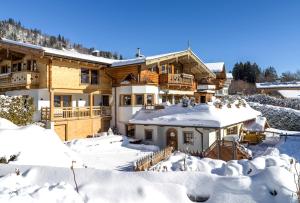 a house in the snow with snow covered yard at TraumChalet mit Sauna in Kirchberg im Skigebiet Kitzbühel in Kirchberg in Tirol
