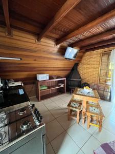 eine Küche mit einem Herd und einem Tisch im Zimmer in der Unterkunft Chalé Represa Varanda do Sol - Chalé Alvenaria in Joanópolis + 28 Fotos