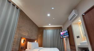 a hotel room with a bed and a tv on the ceiling at Kooch Aparthotel in Oaxaca City