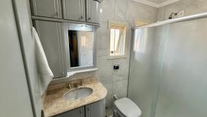a bathroom with a sink and a shower and a toilet at Pousada Tedesco in Bento Gonçalves