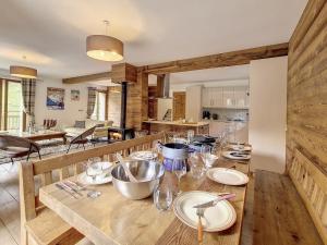 a wooden table with plates and glasses on it in a kitchen at Chalet de standing spacieux avec terrasse et babyfoot - FR-1-344-1186 in Praranger