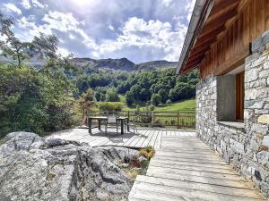 a wooden patio with a table and a view of mountains at Chalet de standing spacieux avec terrasse et babyfoot - FR-1-344-1186 in Praranger