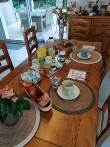 a wooden table with breakfast food on it at Les hortensias in Soubran
