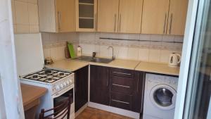 a small kitchen with a sink and a washing machine at Затишна квартира в центрі Оболоні м Київ in Kyiv +7 photos