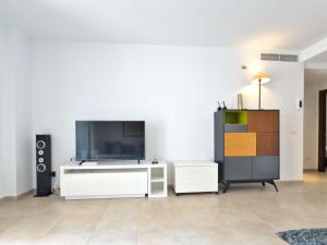 a living room with a large screen tv and a dresser at Apartamento en Los Monteros in Marbella