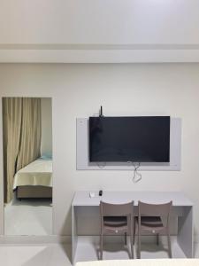 ein Wohnzimmer mit Fernseher und Tisch und Stühlen in der Unterkunft Studio 14 - 2K Atalaia Apenas 150m da Orla in Aracaju