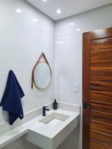 ein Badezimmer mit Waschbecken und Spiegel in der Unterkunft Studio 14 - 2K Atalaia Apenas 150m da Orla in Aracaju + 11 Fotos