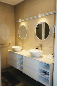 a bathroom with two sinks and two mirrors at LUMA RESIDENCES - Premium Cozy 3-Bedroom Stay in Paramaribo +14 photos