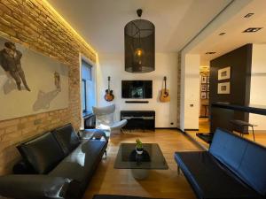 a living room with a couch and a table at Downtown Retreat Loft-Industrial Studio in Rīga