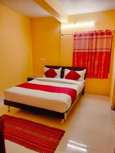 a bedroom with a large bed with red curtains at Harvest Hill View Cottage in Ooty
