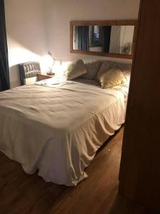 a large bed in a bedroom with a mirror at El milagro in La Reja