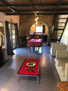a living room with a table and a red rug at El milagro in La Reja