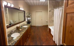 ein Badezimmer mit zwei Waschbecken und einem großen Spiegel in der Unterkunft The Loft at Bite Me BBQ in Wichita + 26 Fotos