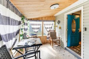 a porch with a blue door and chairs at Family-Friendly Home with Furnish Patio in Crystal! in Island Falls