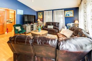 a living room with a leather couch and chairs at Family-Friendly Home with Furnish Patio in Crystal! in Island Falls