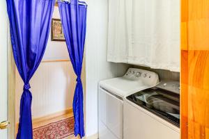 a kitchen with a blue curtain next to a washing machine at Family-Friendly Home with Furnish Patio in Crystal! in Island Falls +24 photos