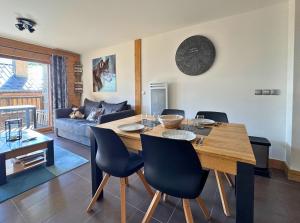 a living room with a dining table and a clock on the wall at Arpette Appartement 2/4 personnes au pied des pistes in Champagny-en-Vanoise +10 photos
