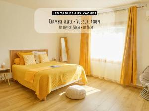 una camera da letto con un letto con una coperta gialla e una finestra di Les Tables Aux Vaches à la Salvetat a La Salvetat
