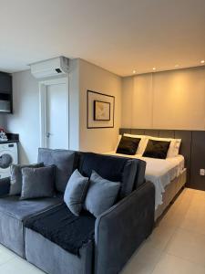 a living room with a couch and a bed at Loft com ar-condicionado no Centro in Guarapuava