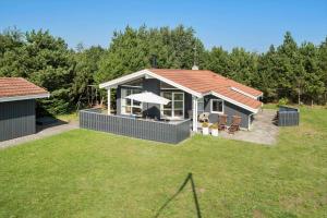 a small house with a deck with a grill at 30872-Ulfborg-Bellisvej-514 in Ulfborg