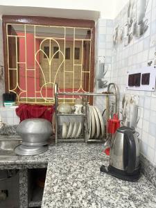 a kitchen with a counter top with a sink and a counter top at Kolkata Vintage Stay - 2BHK with Bengali Home Vibe in Kolkata +39 photos