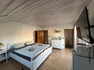 una camera da letto con un letto bianco e una cucina di Landhaus Bad Rotenfels - Bethel a Gaggenau