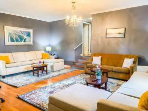 a living room with couches and a chandelier at Cardinal Aerie in Madison