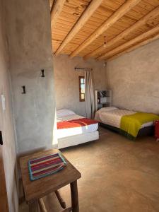 a room with two beds and a table in it at Rancho Raíz in Barreal