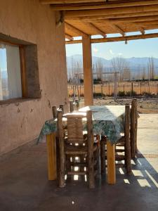 a table and chairs in a building with a window at Rancho Raíz in Barreal
