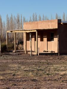a building that is sitting in a field at Rancho Raíz in Barreal
