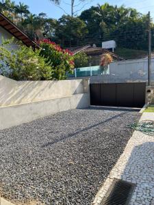 ブルスケにあるCasa ampla com área externa e estacionamentoの擁壁とガレージのある私道