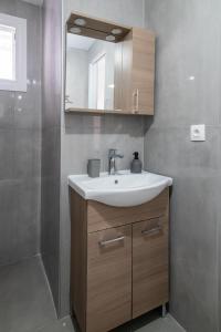 a bathroom with a sink and a mirror at Dore Appartments in Nea Fokea