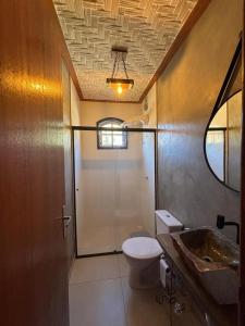 ein Badezimmer mit Toilette, Dusche und Waschbecken in der Unterkunft Chalé em Conceição do Ibitipoca in Lima Duarte + 4 Fotos