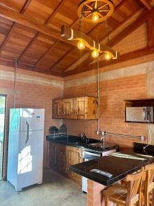eine Küche mit einem weißen Kühlschrank und Holzwänden in der Unterkunft Chalé em Conceição do Ibitipoca in Lima Duarte