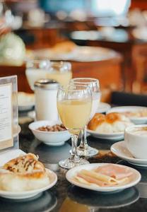 Una mesa con platos de comida y una copa de vino. en Argentino Hotel, en Mar del Plata