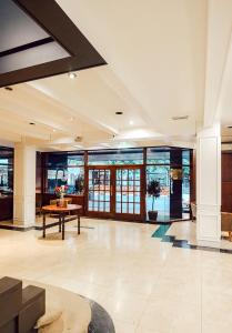 Un gran vestíbulo con una mesa y algunas ventanas. en Argentino Hotel, en Mar del Plata