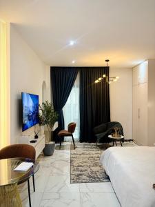 a hotel room with a bed and a living room at A Tranquil Studio in Airport Residential with Pool - The Essence in Accra