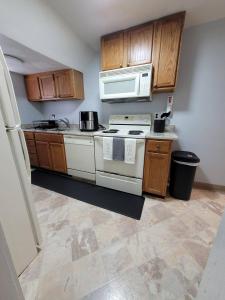 a kitchen with a white stove and wooden cabinets at Cozy 2-BR Retreat Private Parking Near Downtown in Wilmington