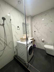 a bathroom with a washing machine and a sink at A Tranquil Studio in Airport Residential with Pool - The Essence in Accra