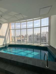 a swimming pool in a building with a large window at Get a Flat 405 Noble-Jardins Neighborhood - SP in Sao Paulo