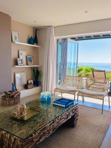 a living room with a table and a view of the ocean at Shades of Blue in St Helena Bay