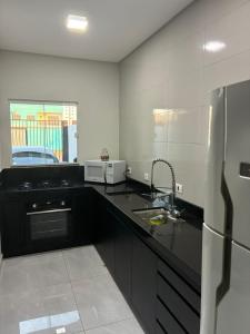 une cuisine avec un évier et un réfrigérateur dans l'établissement Casa em foz do iguaçu, à Foz do Iguaçu