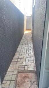 une ruelle en briques avec un mur et un bâtiment dans l'établissement Casa em foz do iguaçu, à Foz do Iguaçu