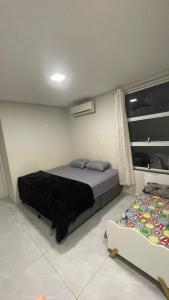 une chambre avec un lit et un canapé dans l'établissement Casa em foz do iguaçu, à Foz do Iguaçu