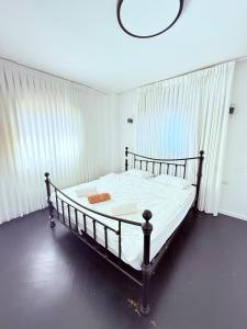 a bedroom with a bed with white sheets and a chandelier at Royal Retreat 6 Luxury Suites Villa & Pool in Herzliyya B