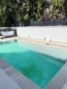 a swimming pool with turquoise water at Royal Retreat 6 Luxury Suites Villa & Pool in Herzliyya B +7 photos